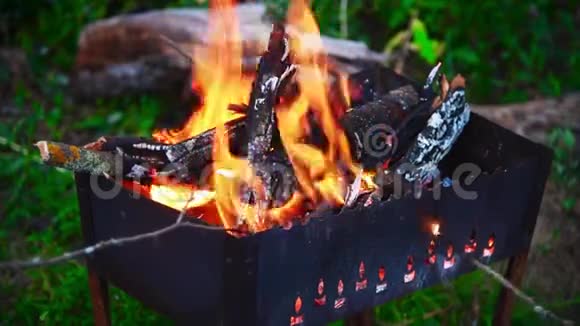 人们坐在火炉旁不时地用木棍在坟墓里翻燃柴火视频的预览图