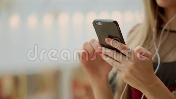 女孩使用手机模糊的形象内商城作为背景视频的预览图