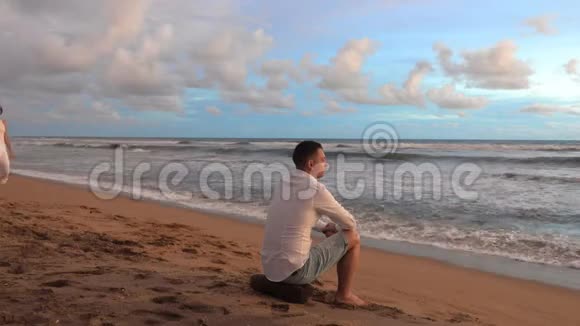 年轻的情侣在浪漫的约会中遇见海滩上的日落视频的预览图