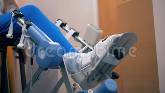 人坐在椅子上在一台特殊的机器上接受腿部治疗4K视频的预览图