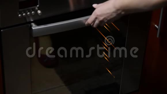 一只雌性手把一个带有手工面包的烤盘放在家庭烤箱里视频的预览图
