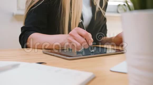 在办公室从事平板电脑工作的商界女性漂亮的金发女性一头长发穿着优雅的西装坐在木制的视频的预览图