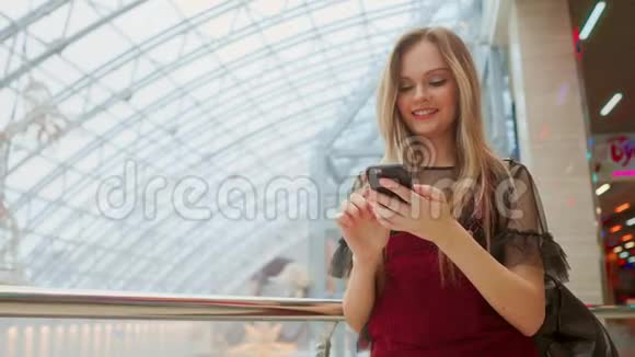 女孩使用手机模糊的形象内商城作为背景视频的预览图