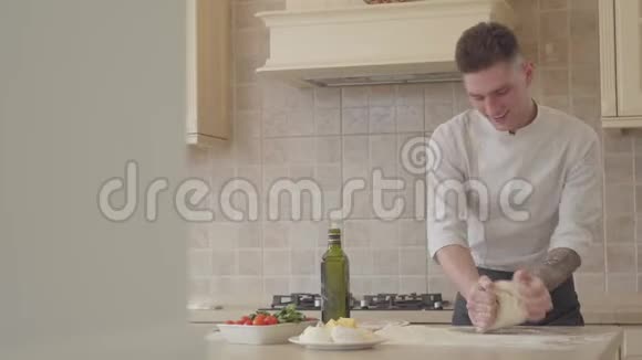 专业的比萨饼师熟练和快速揉面比萨饼在现代厨房橄榄油视频的预览图