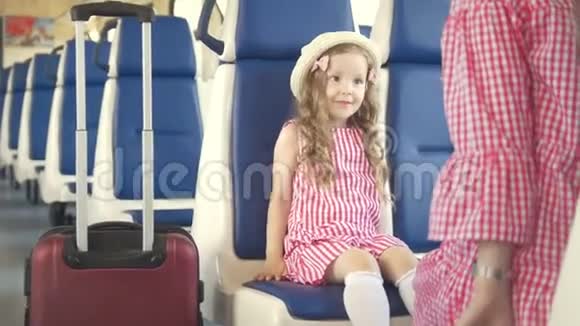年轻女子带着她的小女儿拿着行李箱离开了火车视频的预览图