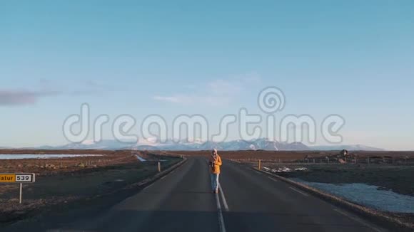 在空无一人的山路上的女旅行者视频的预览图
