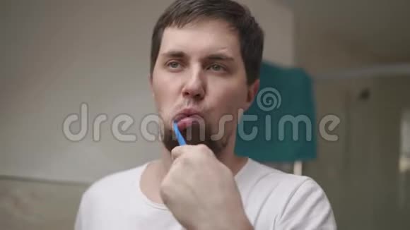 年轻人早上在浴室用牙刷刷牙特写视频的预览图