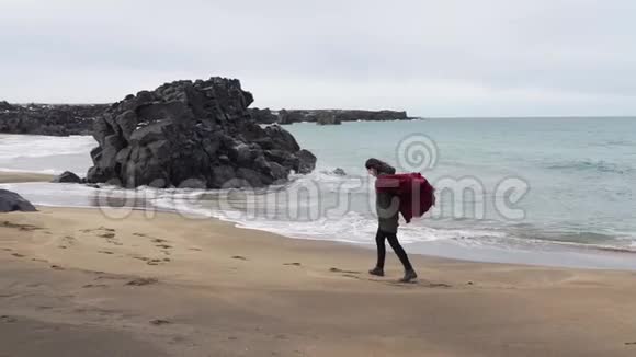天气寒冷一个女孩走在海边视频的预览图