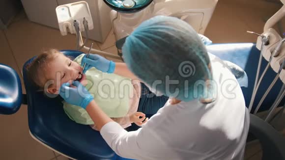 在牙科医生接待的女孩口腔医生检查了孩子牙齿可爱顽皮的女孩微笑着视频的预览图