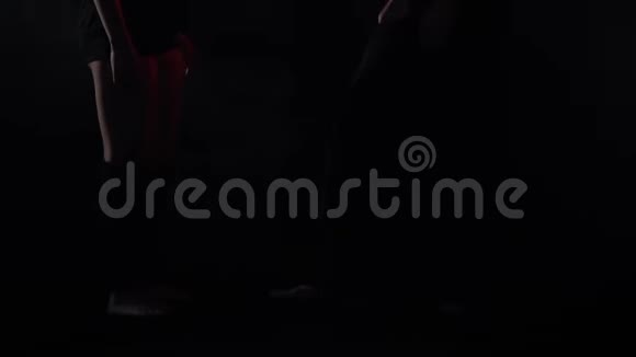 一对夫妇在红光下练习杂技瑜伽一个男人在空中举起一个女人视频的预览图