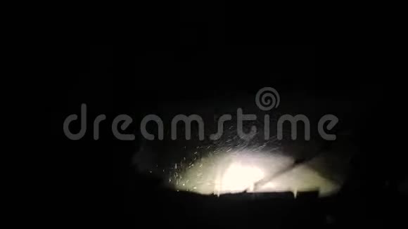 在冻土带中间的一个下雪的夜晚从一辆雪车上捕捉道路的视频视频的预览图