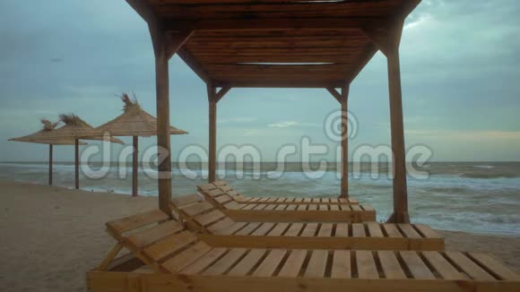 海滩露台对面的晨海景观有木制的日光浴床视频的预览图