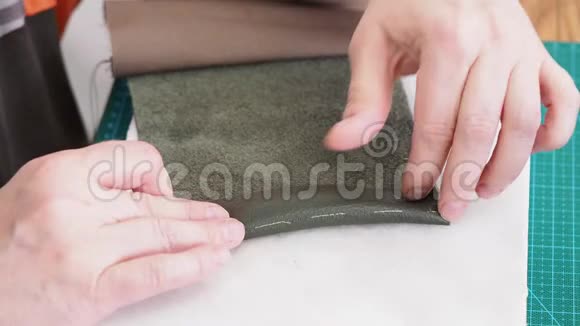 工匠在皮革口袋边缘涂上胶水视频的预览图