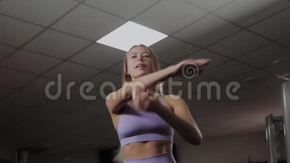 有一个漂亮身材的运动女人在训练前做伸展运动视频的预览图