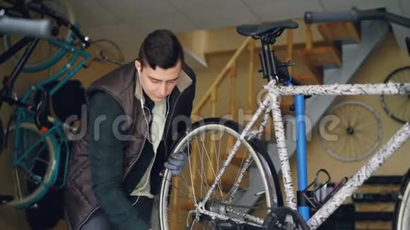 有经验的机械师正在工作场所维修车辆时组装自行车调整后轮专业人员视频的预览图
