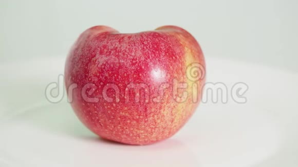 白色盘子上切成两半的粉红色苹果水果视频的预览图