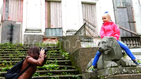 母亲在废弃的石头废墟上给女儿拍照视频的预览图