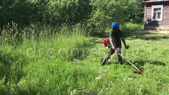 一个男人用汽油编织斜斜斜斜从一侧到另一侧提高防护网检查草坪视频的预览图