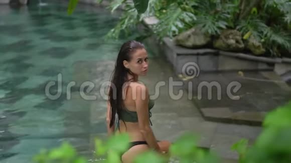 一个年轻的长发女子慢镜头从泳池里出来视频的预览图