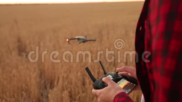 农夫双手握着遥控器四架直升机在后台飞行无人机在后面上升视频的预览图