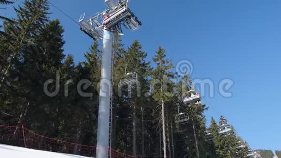 滑雪者乘坐滑雪电梯冬天阳光明媚的一天在山上视频的预览图