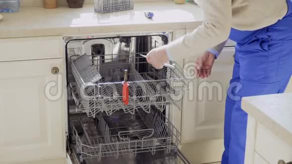 成熟的师傅在厨房修理洗碗机视频的预览图