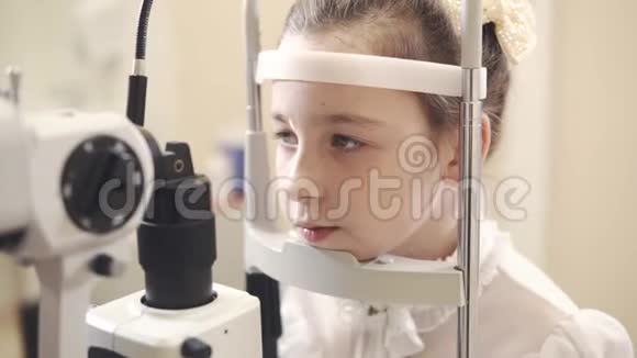 一家综合诊所的眼科医生检查她视力的女孩画像视频的预览图