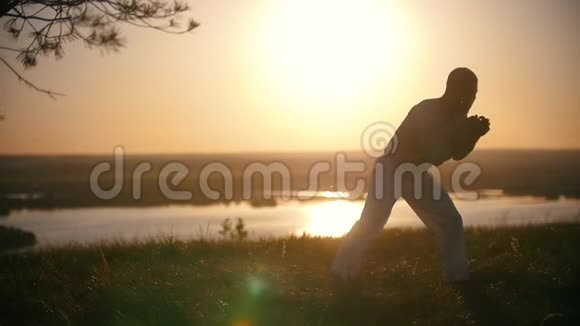这位拳击手在夕阳的背景下慢慢地踢腿视频的预览图