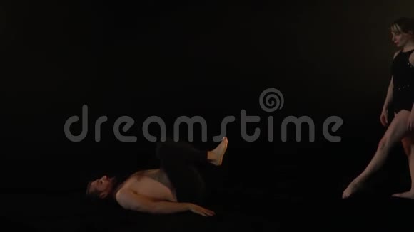 一个男人伸展他的腿一个女人躺在腿上练习瑜伽视频的预览图