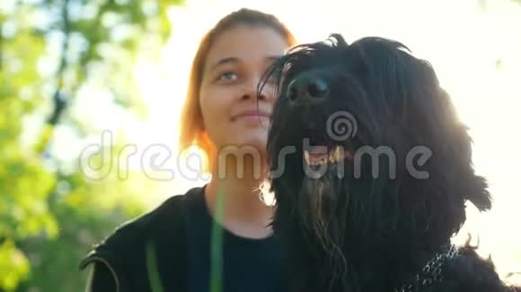 女孩和她的狗坐在公园的草地上阳光明媚夏日视频的预览图