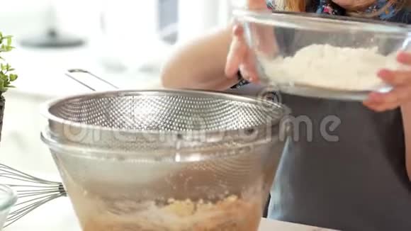 小女孩面包师用筛子筛面粉视频的预览图
