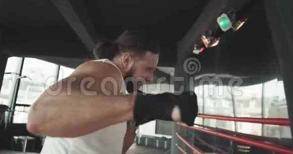 拳击手在健身房中以慢动作击中拳击袋年轻人在室内训练体育健将视频的预览图