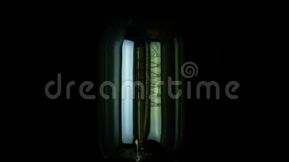 开启和关闭慢动作一个复古老式灯泡与旧技术与灯丝内置温暖的光视频的预览图