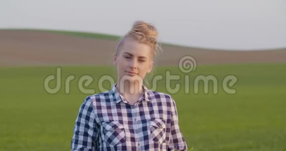 自信的女农民在农场展示年轻作物视频的预览图