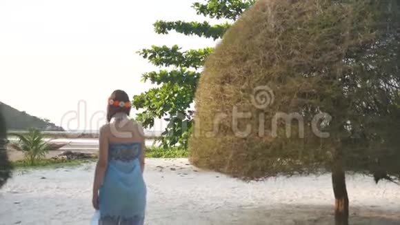 年轻女孩走在热带树木之间视频的预览图