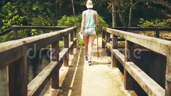 女孩正沿着丛林中一座废弃的桥走着视频的预览图