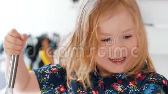 快乐的小女孩混合了烘焙饼干的原料视频的预览图
