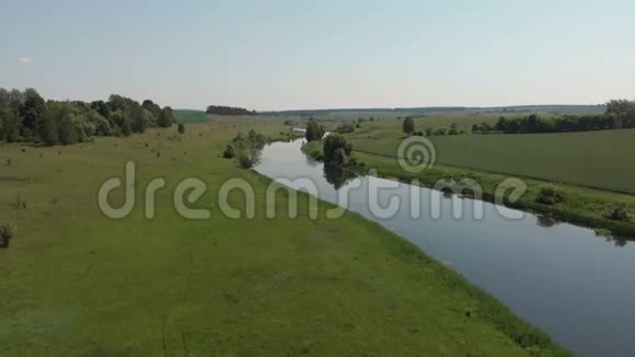 河的顶部景色两岸环绕着树木和草地从顶部空中俯瞰视频的预览图