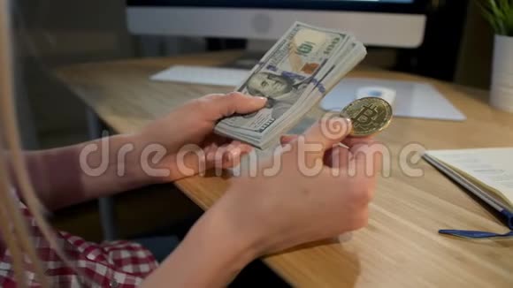 持有比特币和现金的女人女性手握金属比特币和美元钞票的作物观察视频的预览图