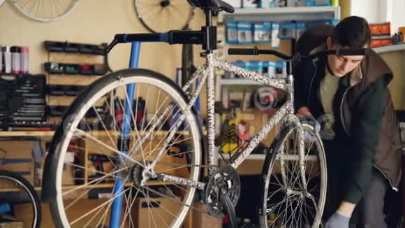 熟练的修理工集中在修理自行车车轮用专业扳手固定它同时在小范围内工作视频的预览图