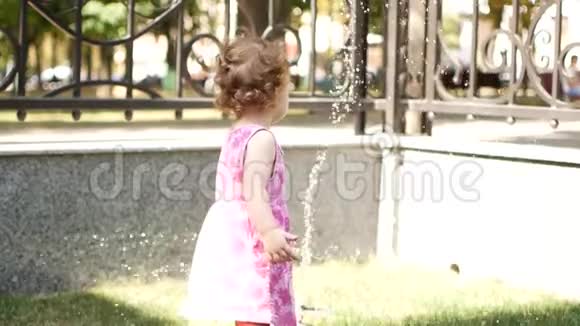 幼儿女孩正试图处理喷泉里的水视频的预览图