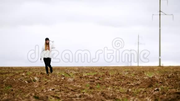 一位美丽的年轻女子走在秋天的田野上视频的预览图