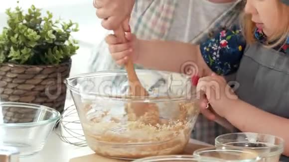 小女孩面包师揉面团大木勺视频的预览图
