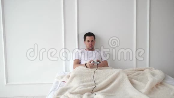 男人在床上玩游戏机视频的预览图