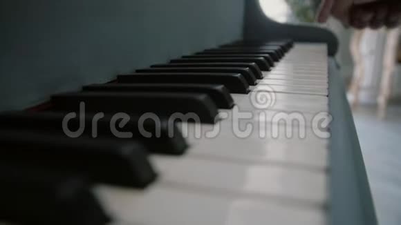 一个人手指着钢琴的琴键演奏钢琴的男乐手弹钢琴的钢琴家的手指视频的预览图