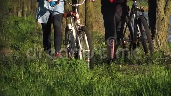 慢镜头拍摄一对骑自行车的人穿过森林视频的预览图