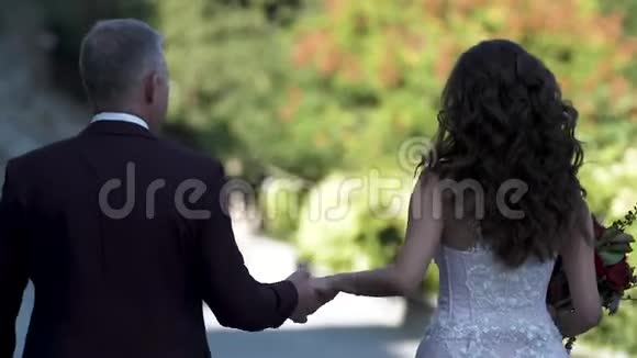 新郎和新娘走在小巷里情侣牵着手向前看视频的预览图