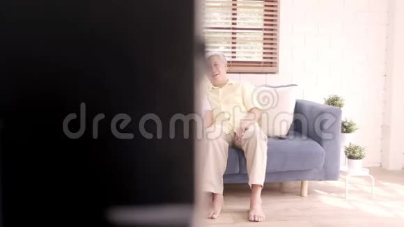 亚洲老年夫妇在家客厅看电视视频的预览图