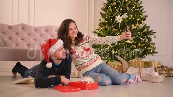 幸福的年轻夫妇带着自拍在装饰的圣诞房新年快乐理念可爱的家庭视频的预览图