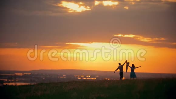 明亮的橙色日落家庭与小男孩在大自然中休息牵手视频的预览图